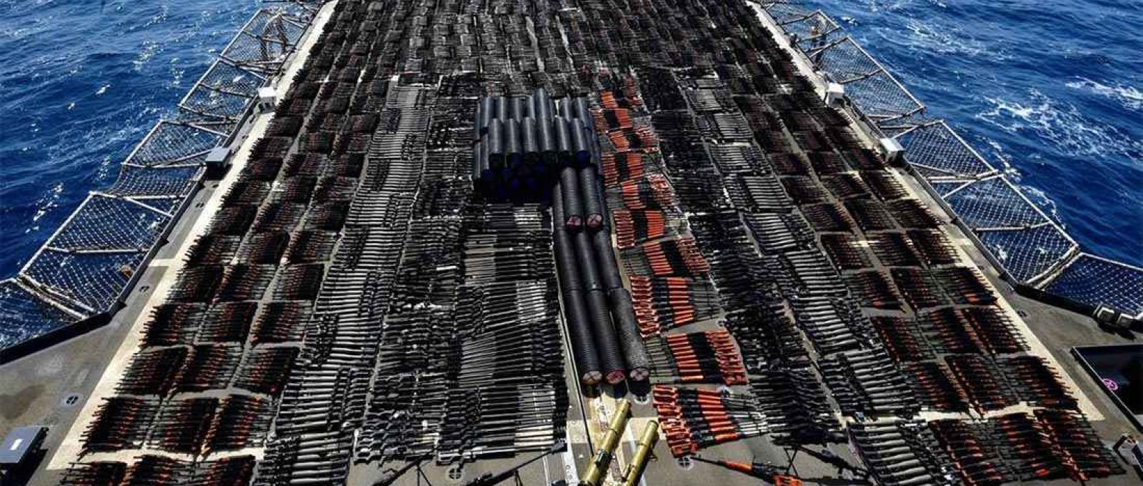 Milhares de armas são exibidas a bordo do cruzador USS Monterey, apreendidas em embarcação sem bandeira em águas internacionais do Mar da Arábia (Foto: US Navy/Reuters).