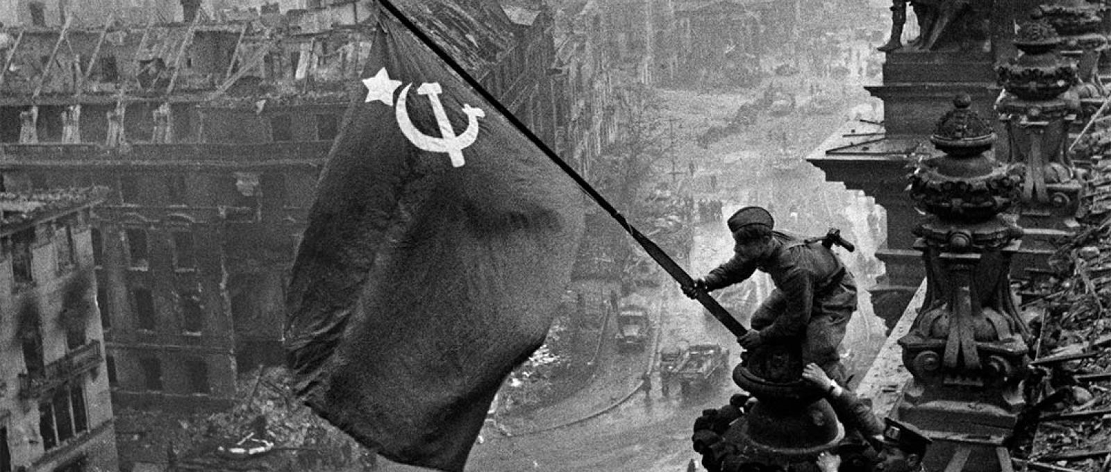 O soldado Abdoulkhakim Ismaïlov levanta a bandeira soviética sobre o Reichstag, imagem que se tornou o símbolo da derrota da Alemanha nazista na Segunda Guerra Mundial (Yevgeny Khaldei/TASS).