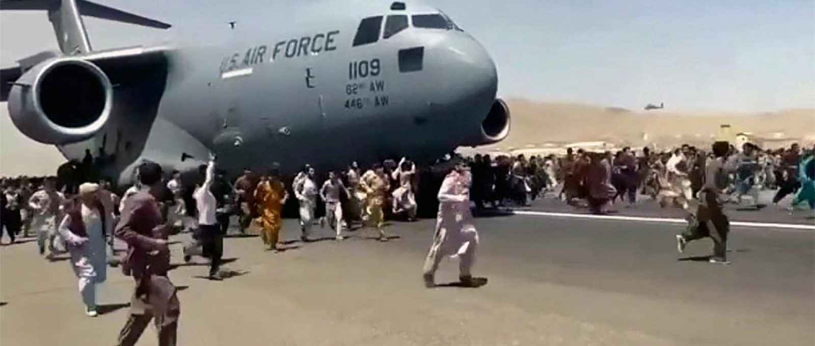 Centenas de pessoas correm ao lado de uma aeronave de transporte C-17 da USAF enquanto ele taxia pela pista do aeroporto de Cabul, Afeganistão, em 16 de agosto de 2021 (Foto: Politico/UGC via AP).