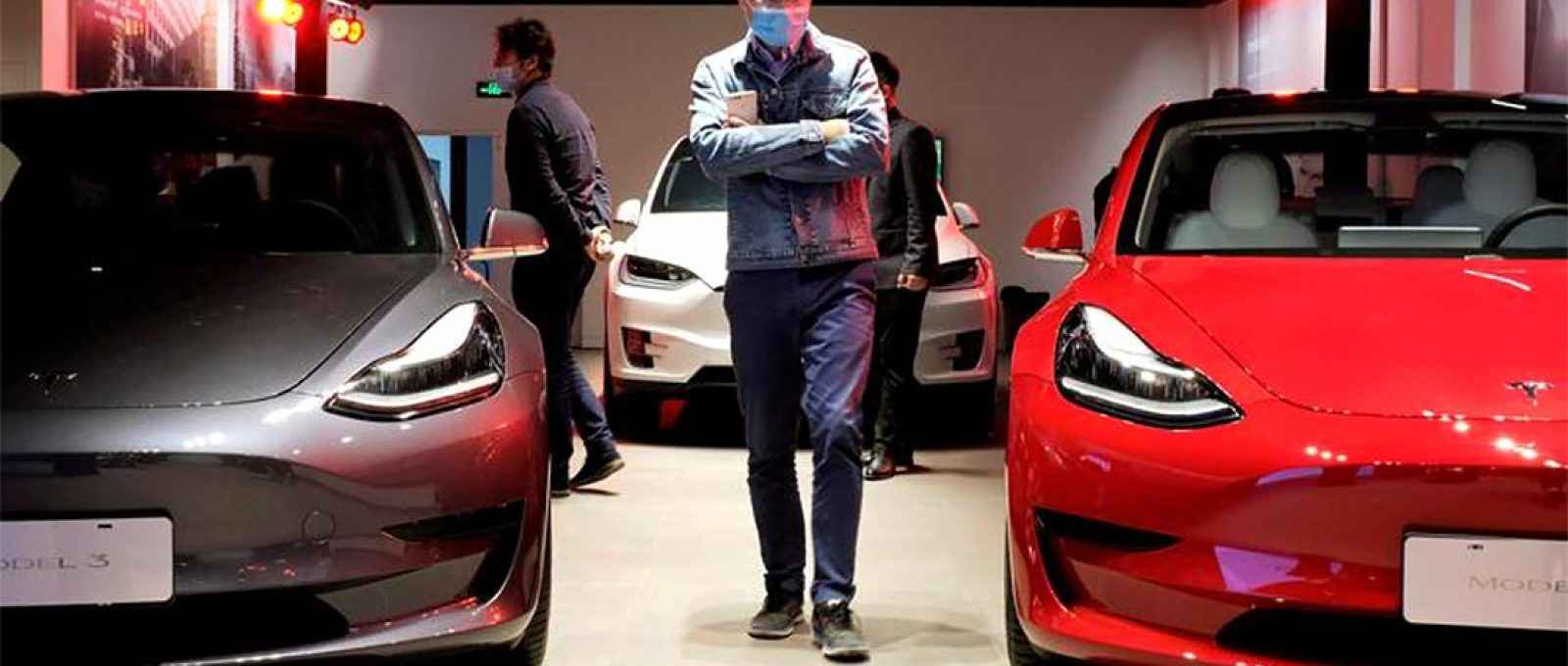 Um homem caminha entre os sedãs Tesla Model 3 e o veículo utilitário esportivo Tesla Model X em um showroom da Tesla em Xangai, China, 8 de maio de 2020 (Foto: Yilei Sun/Reuters).
