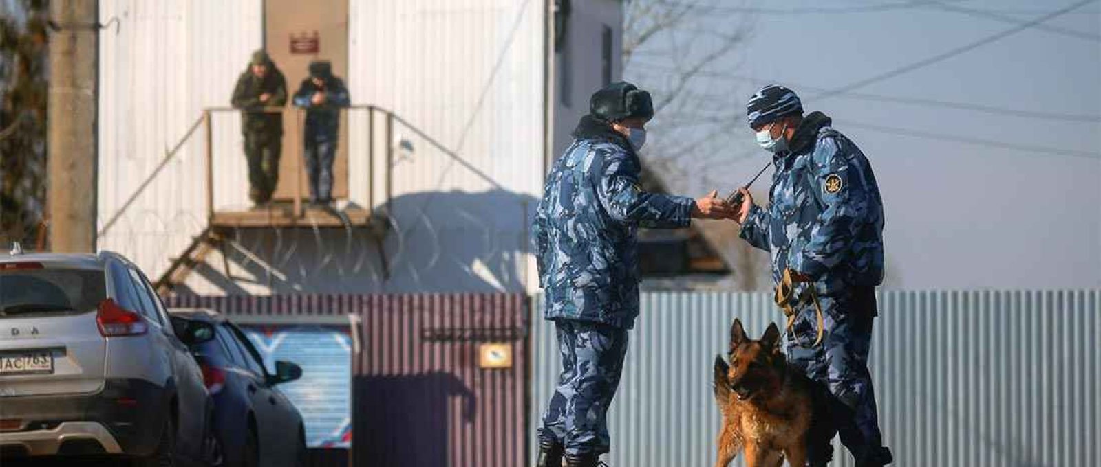 Policiais com um cão de guarda perto de um posto de controle de segurança da colônia penal corretiva IK-2, onde Alexei Navalny cumpre pena, na cidade de Pokrov, Rússia, em 6 de abril de 2021 (Maxim Shemetov/Reuters).