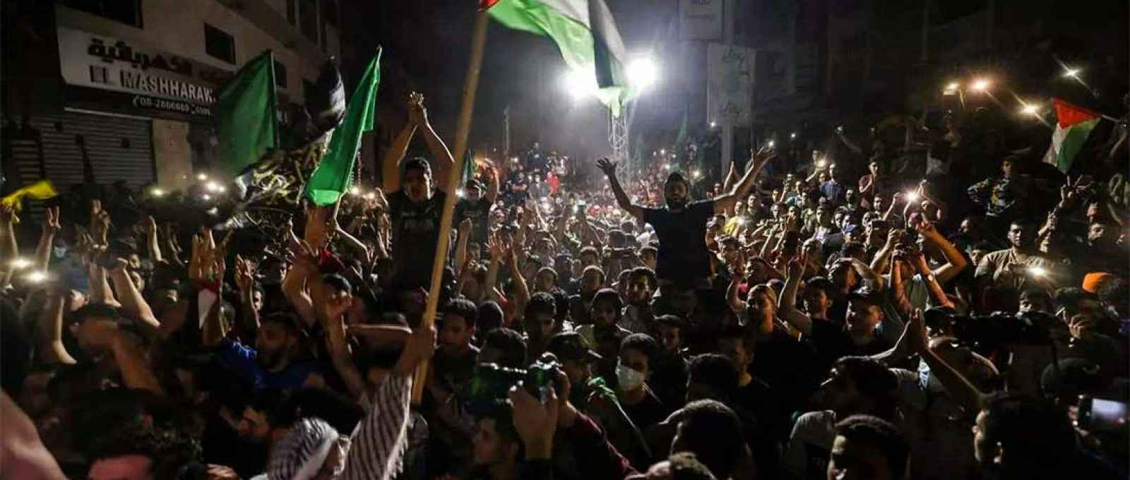 Pessoas saem às ruas na Cidade de Gaza para celebrar um cessar-fogo mediado pelo Egito entre Israel e o Hamas, no início de 21 de maio de 2021 (Foto: Mohammed Abed/AFP).