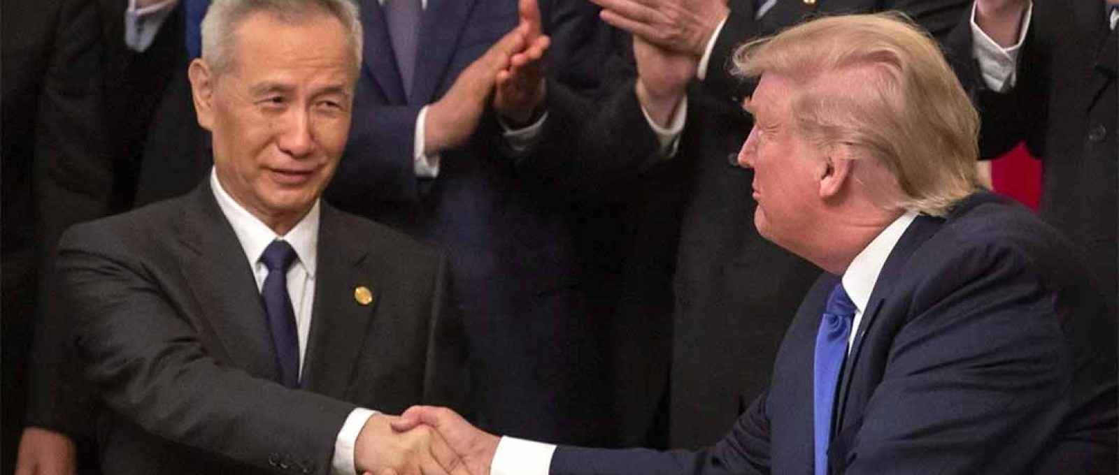 O vice-premiê chinês Liu Ele assina a primeira fase do acordo comercial entre a China e os Estados Unidos com o então presidente americano, Donald Trump, em janeiro de 2020 (Foto: EPA-EFE).