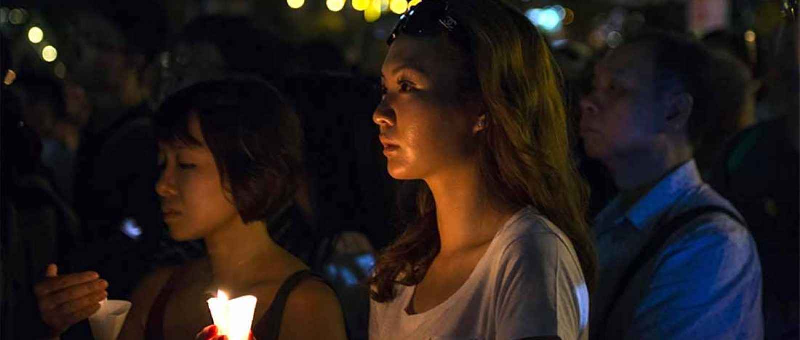Mulher segura uma vela durante a cerimônia pelas vítimas da Praça da Paz Celestial durante uma vigília em Hong Kong em 4 de junho de 2016 (Foto: Albert Bonsfills/Anadolu).