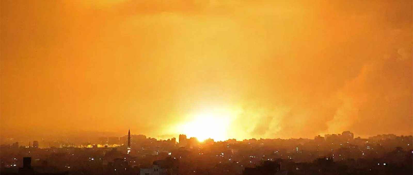 Explosão ilumina o céu após ataque aéreo israelense a Beit Lahia, no norte da Faixa de Gaza, em 14 de maio de 2021 (Foto: Mohammed Abed/AFP).