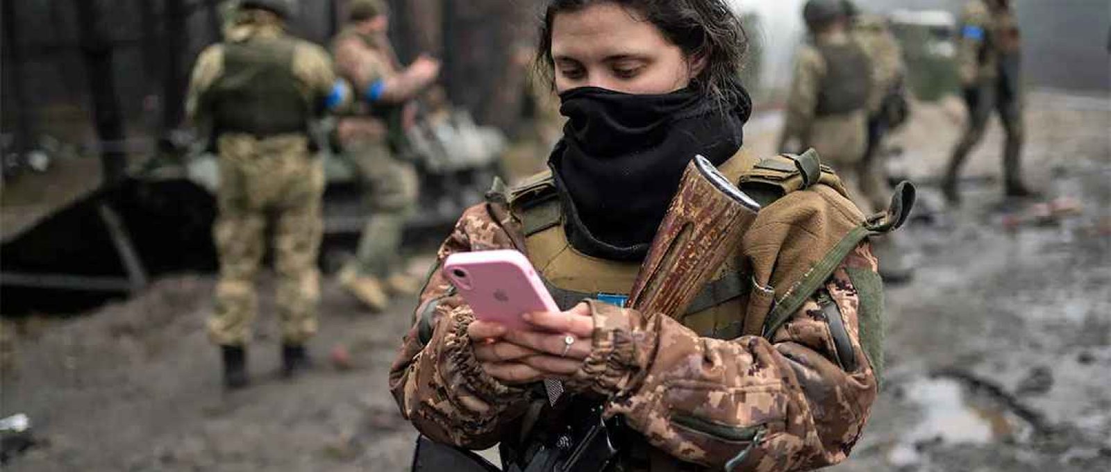 Militar ucraniana verifica seu telefone após uma varredura militar nos arredores de Kiev (Rodrigo Abd/The Associated Press).