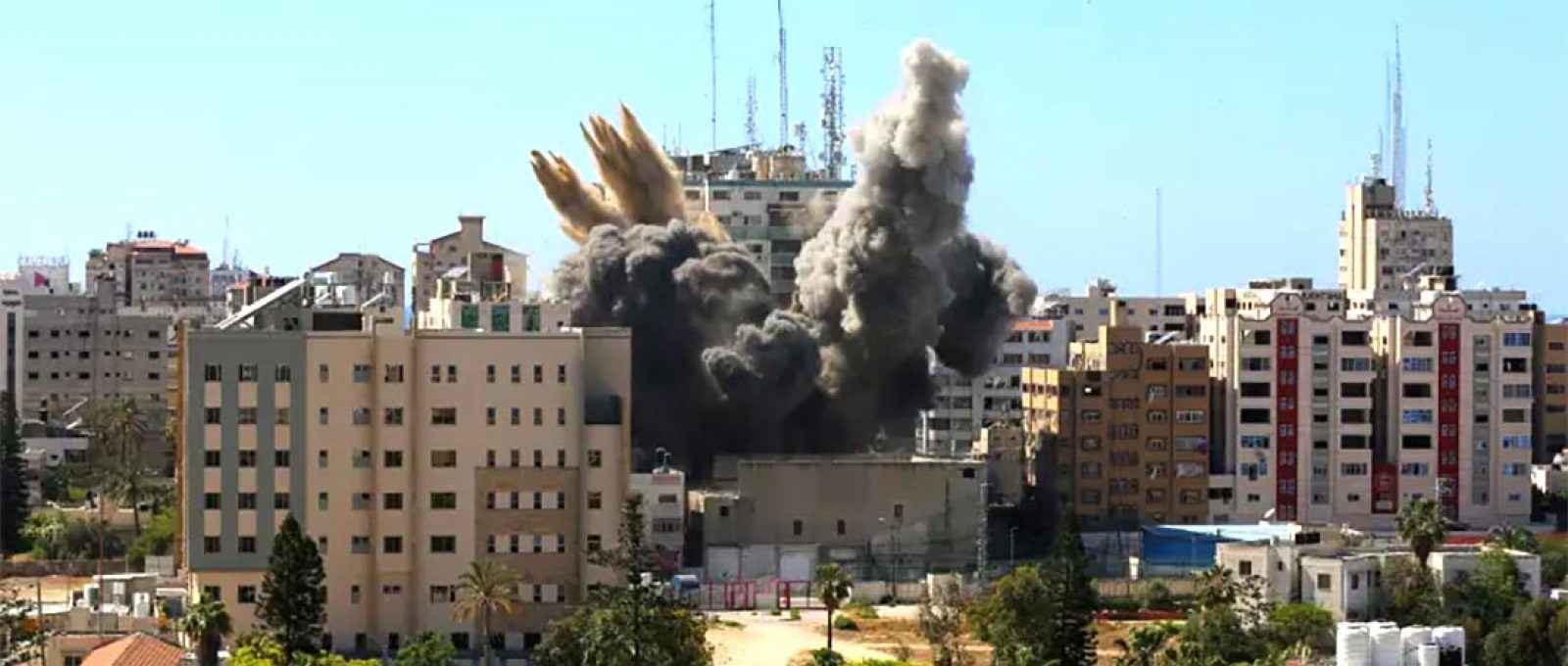 Um míssil cai enquanto a fumaça sobe perto de uma torre que abriga os escritórios da AP, Al Jazeera, durante ataques de mísseis israelenses na cidade de Gaza, 15 de maio de 2021 (Foto: Ashraf Abu Amrah/Reuters).