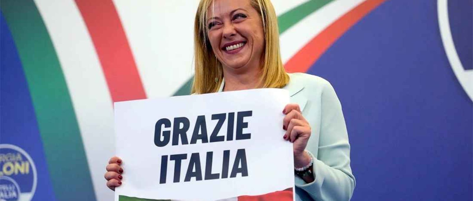 Giorgia Meloni segura cartaz com os dizeres "Obrigado Itália" na sede de seu partido em Roma, em 26 de setembro de 2022 (Gregorio Bórgia/AP).