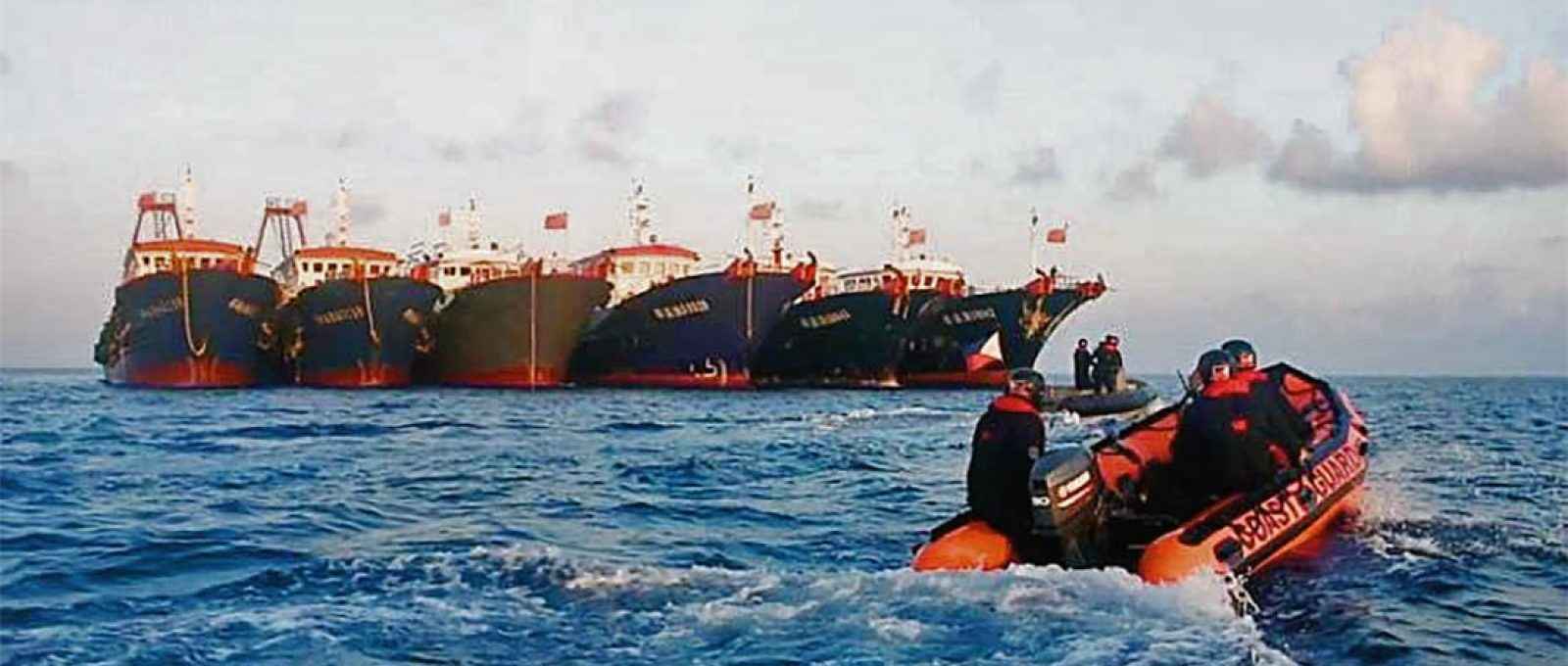 Bote da Guarda Costeira filipina passa por navios chineses perto do Recife Whitsun em 14 de abril (Foto: EPA-EFE).