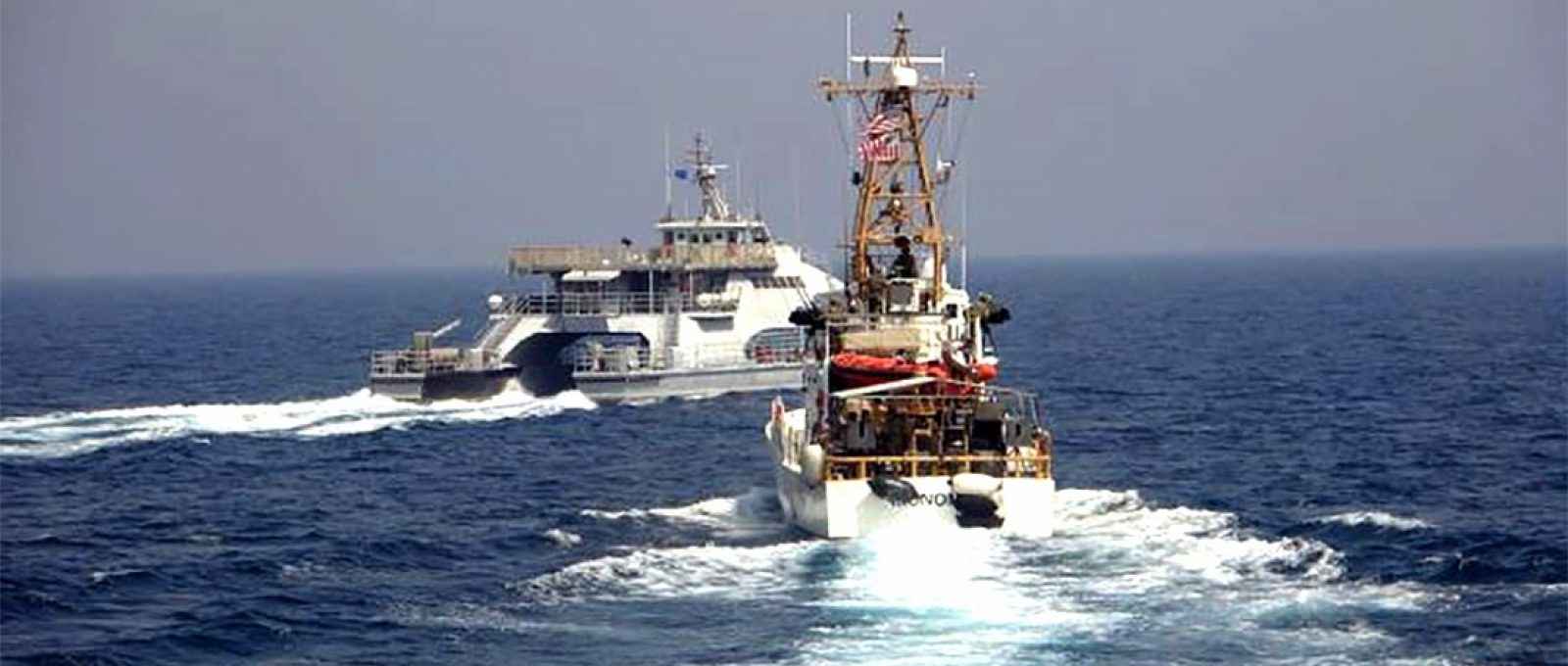 O Harth 55, da marinha do IRGC, à esquerda, cruza a proa do barco de patrulha da Guarda Costeira americana USCGC Monomoy, à direita, enquanto este patrulhava ao sul do Golfo Pérsico (Foto: US Navy).