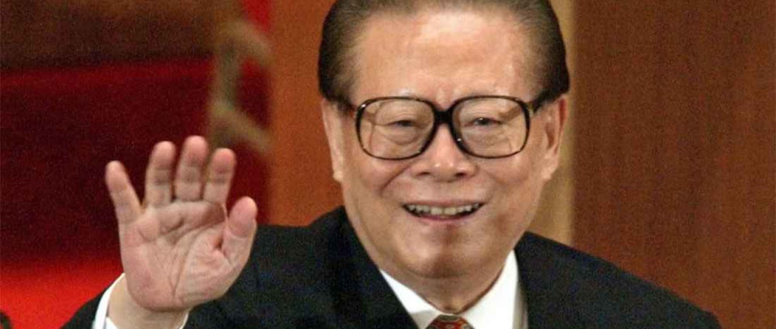 Jiang Zemin acena ao público depois de ser reeleito como presidente da Comissão Militar Central em Pequim em 15 de março de 2003 (Reuters).