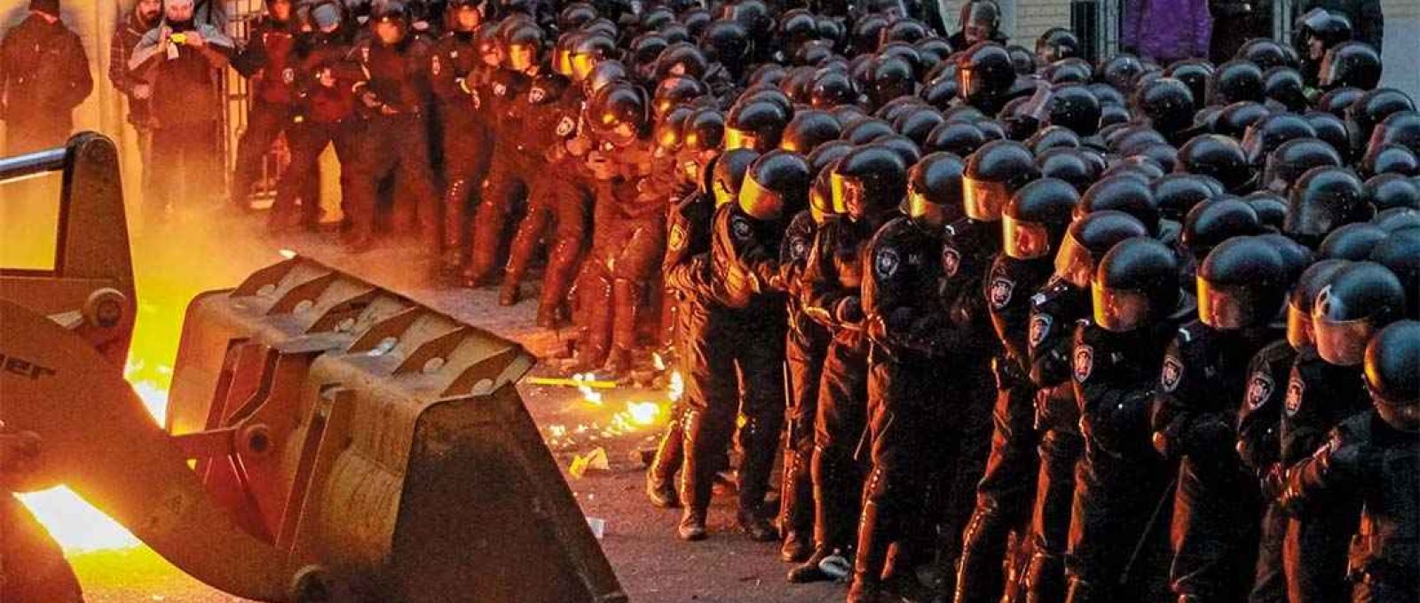 Manifestantes em Kiev, capital da Ucrânia, usam uma escavadeira para tentar romper as linhas policiais durante uma manifestação em 1º de dezembro de 2013 (Gleb Garanich/Reuters/Landov).
