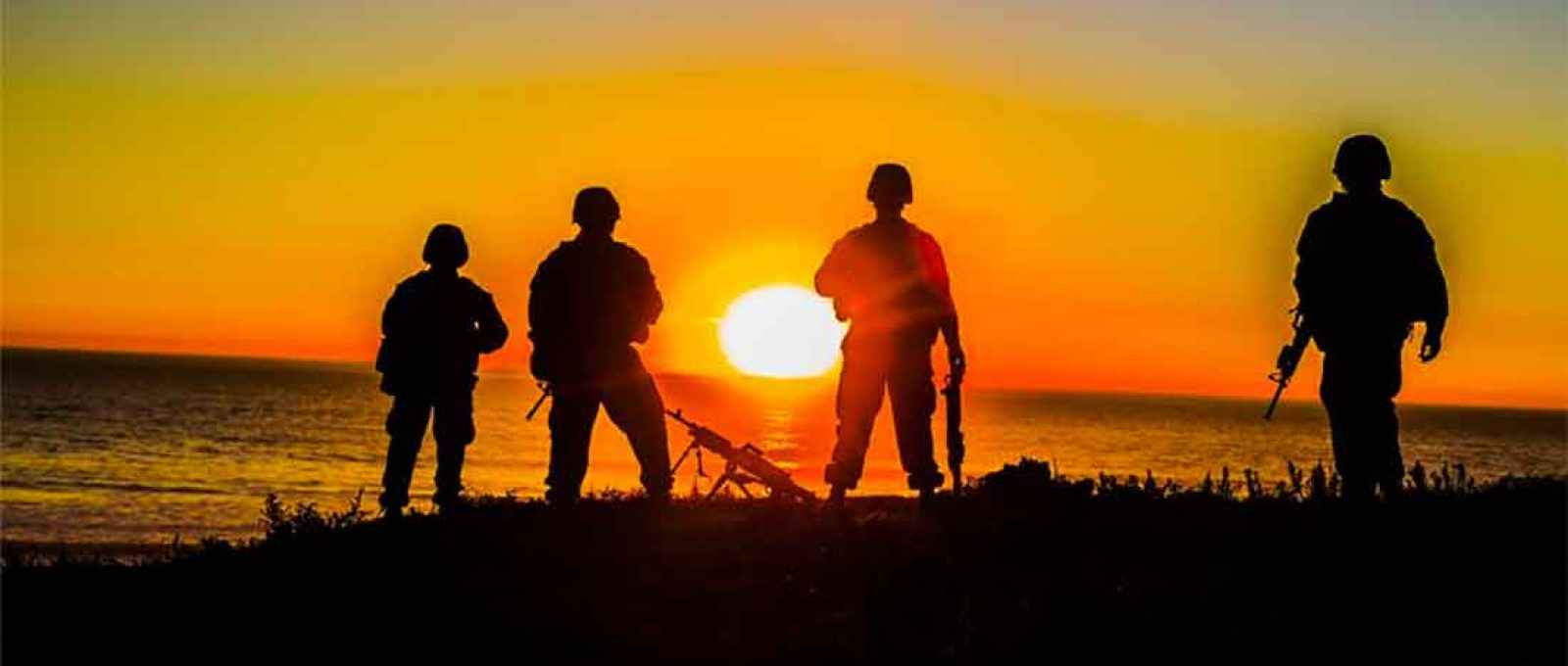 Fuzileiros do 11º Batalhão de Logística de Combate do 1º Grupo de Logística dos Fuzileiros Navais dos EUA, observam o pôr do sol na praia em Camp Pendleton, Califórnia (Foto: Adam Dublinske/US Marine Corps).