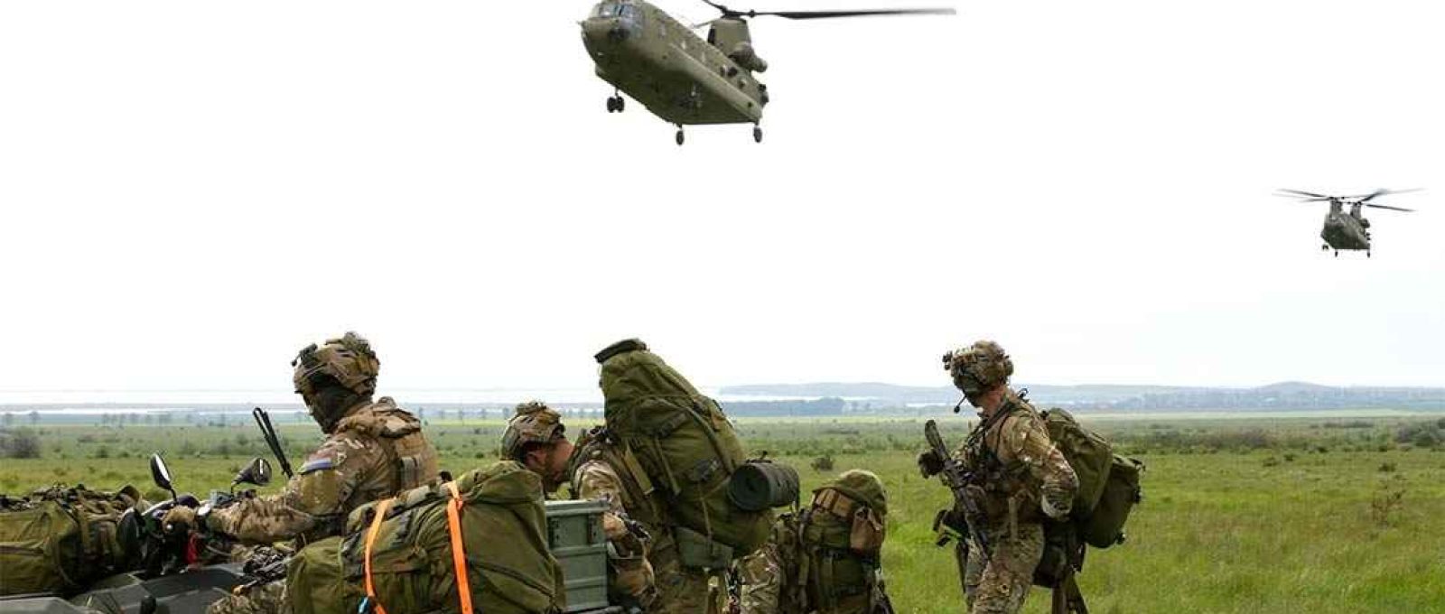 Soldados holandeses preparam equipamento enquanto helicópteros CH-47 Chinook voam para a área de coleta durante o exercício Swift Response 21 na área de treinamento de Babadag, Romênia, em 16 de maio de 2021 (Foto: Sgt. Randis Monroe/US Army).