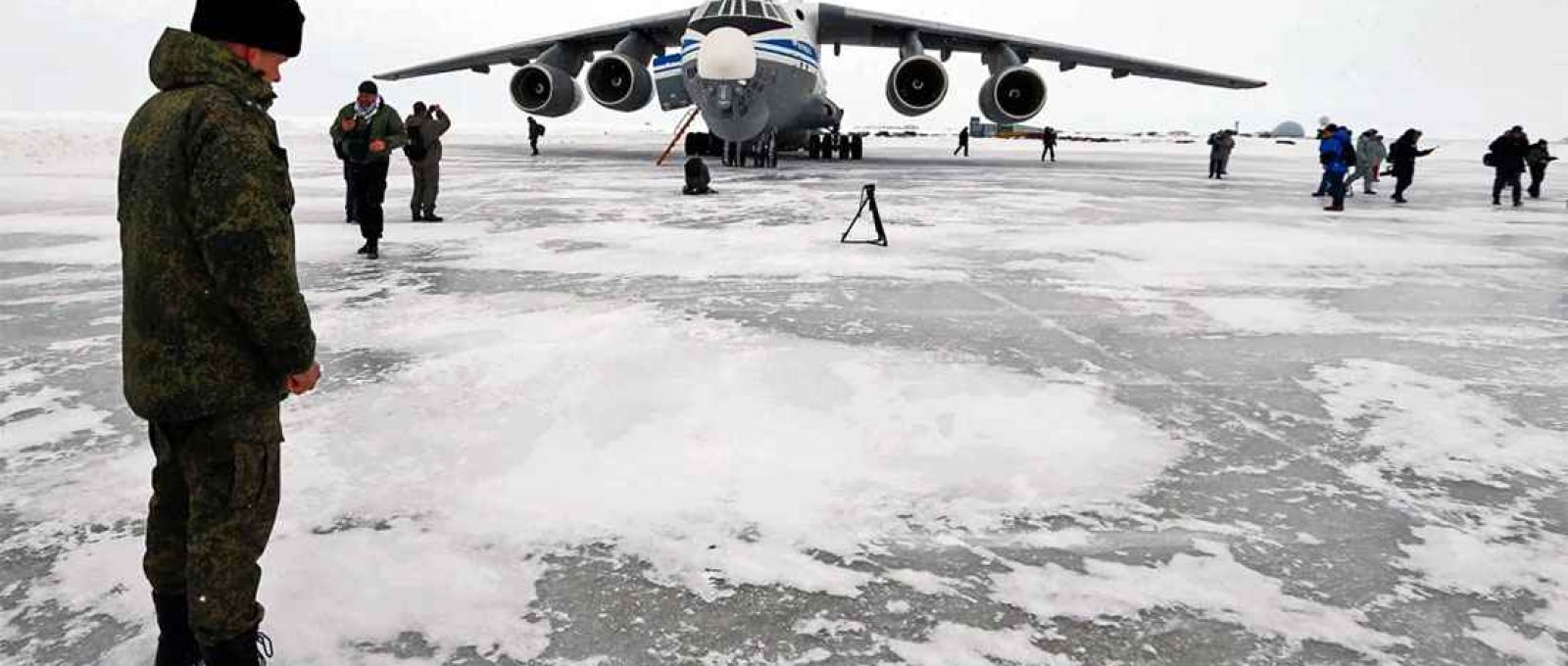 Um oficial russo observa um avião de transporte militar perto de Nagurskaya em Alexandra Land, o posto militar mais ao norte da Rússia (Aleksandr Zemlianichenko/AP).