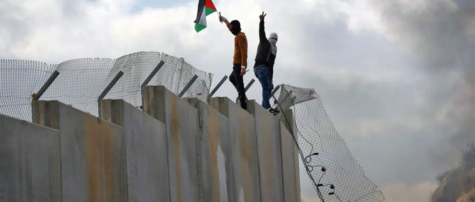 Palestinos escalam muro de separação de Israel entre a aldeia de Bilin, na Cisjordânia, 17 de fevereiro de 2017 (Abbas Momani/AFP via Getty Images).
