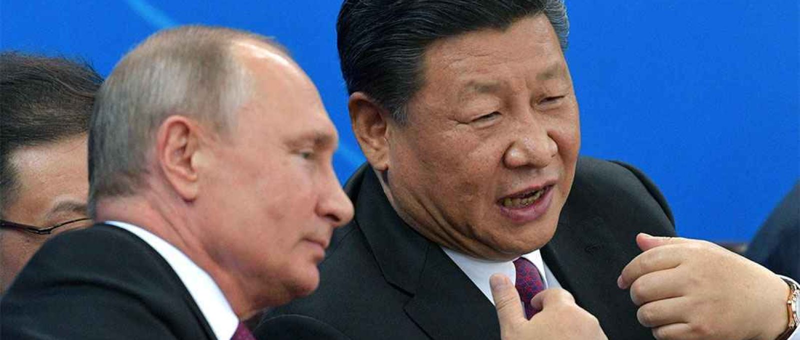 O presidente russo Vladimir Putin e o líder chinês Xi Jinping conversam durante uma partida amistosa de hóquei no gelo entre equipes juniores em Tianjin, China, em junho de 2018 (Sputnik/Kremlin via Reuters).