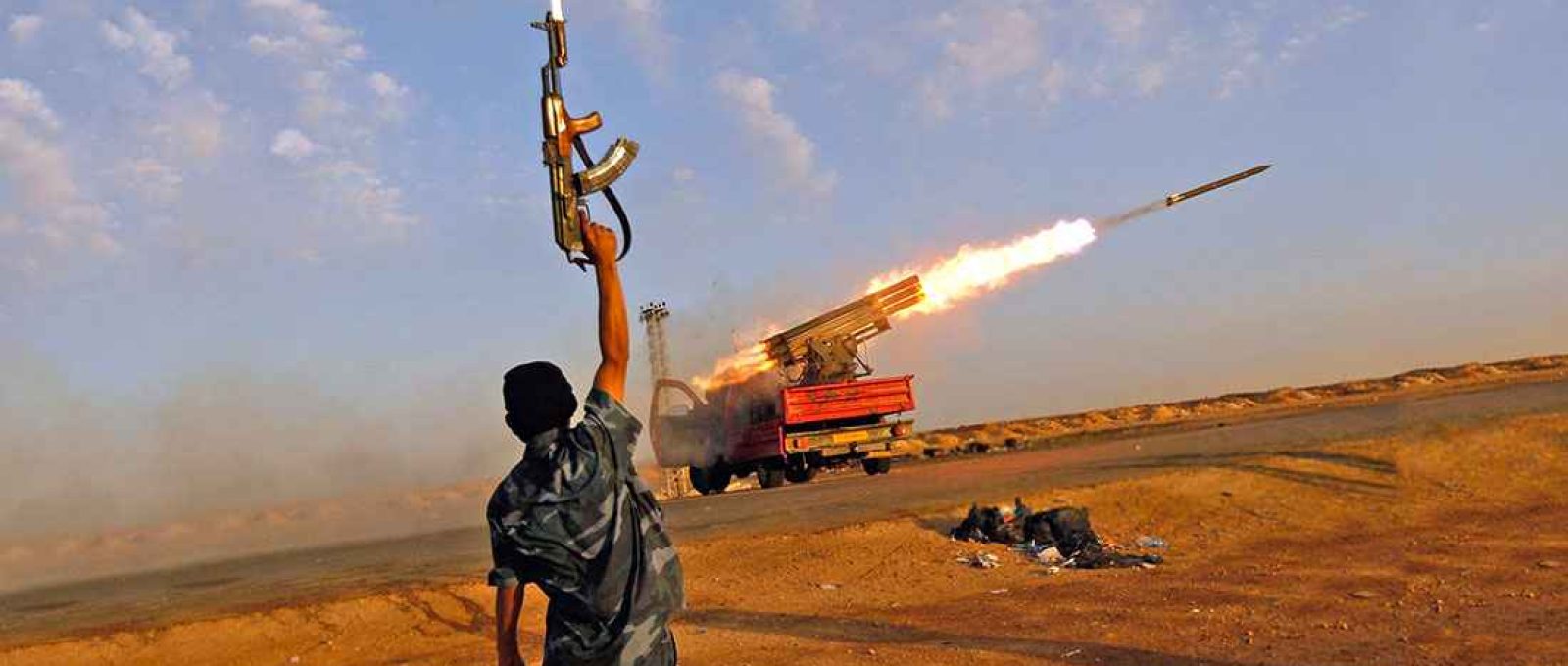 Combatente rebelde comemora o disparo de barragem de foguetes contra tropas leais ao governante líbio Muammar Gaddafi a oeste de Ajdabiyah, na Líbia, 14 de abril de 2011 (Chris Hondros/Getty Images).