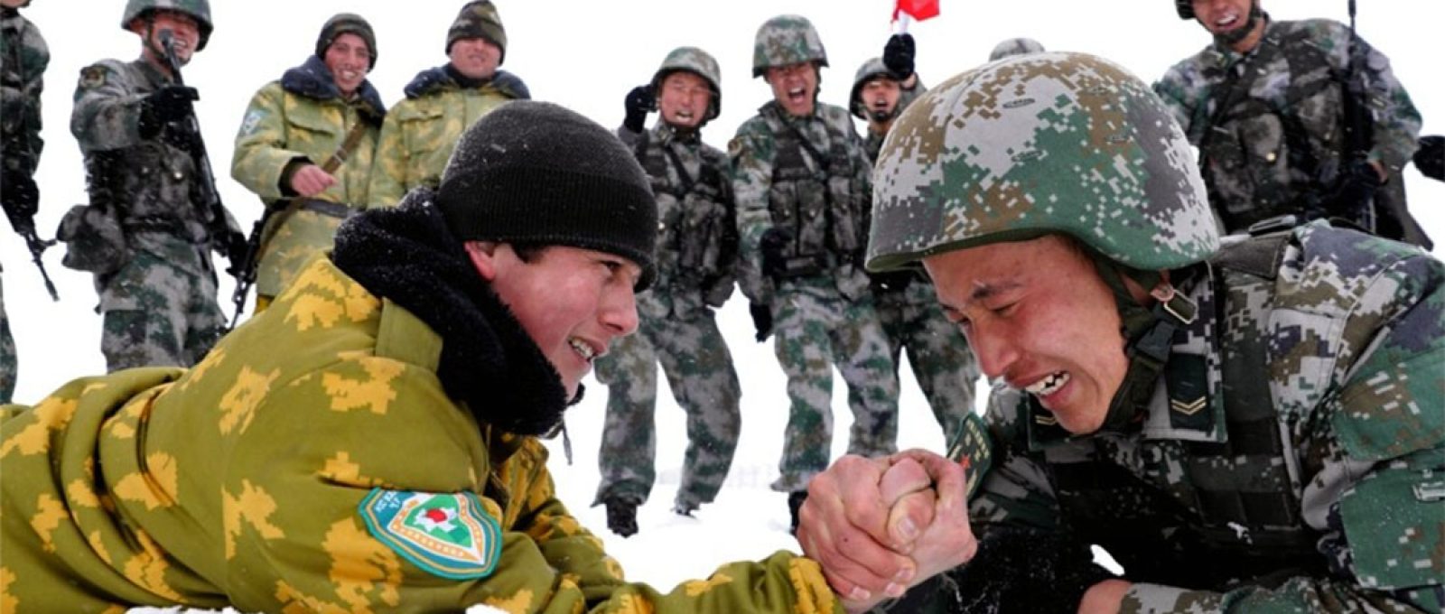 Soldados chineses e tadjiques disputam braço-de-ferro durante patrulhas perto da cidade de Kashgar, na região autônoma de Xinjiang, no noroeste, em maio de 2019 (EPA-EFE).