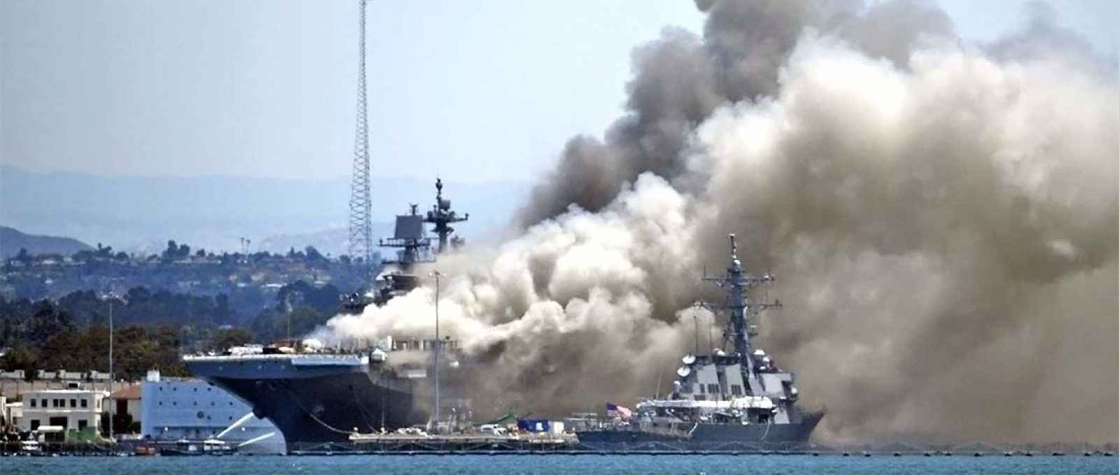 A fumaça encobre o navio de assalto anfíbio USS Bonhomme Richard na Base Naval de San Diego durante o incêndio que tomou o navio em 12 de julho de 2020 (Denis Poroy/AP).